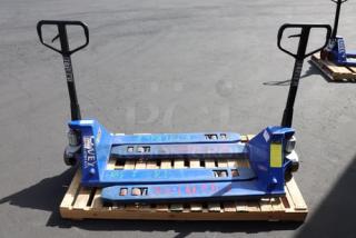 Pair of Lavex pallet jacks on wooden pallet. Blue metal, sturdy handles, visible markings. Used condition.