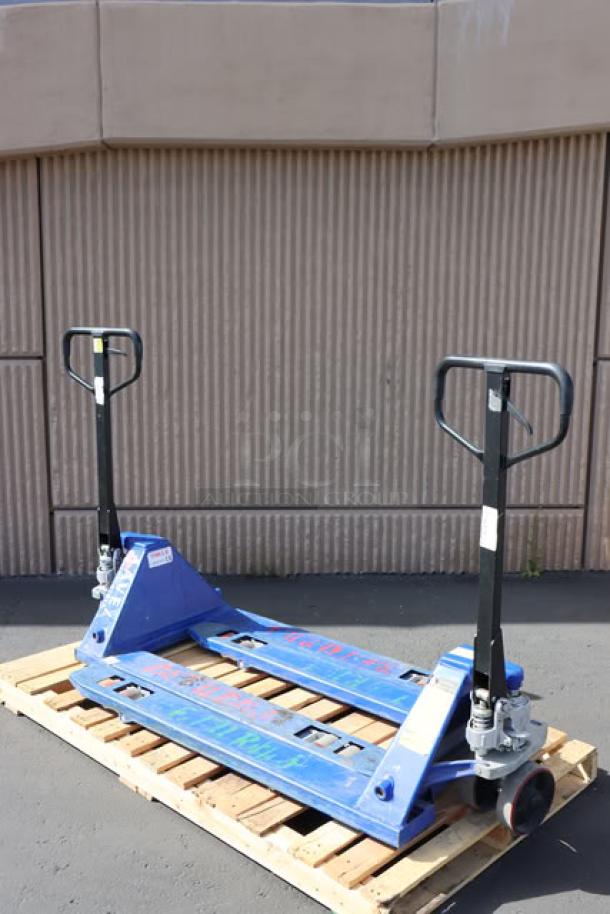 Pair of Lavex pallet jacks on wooden pallet, blue color, sturdy metal construction, visible handles, excellent condition.