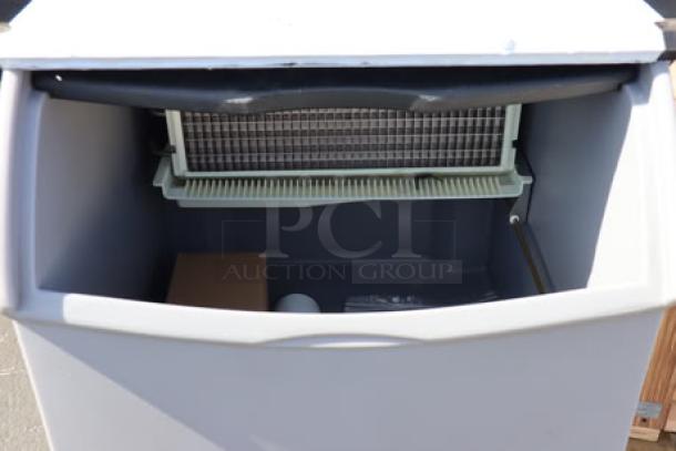 Brand new Ice-O-Matic ICEU220HA air-cooled undercounter ice machine, open bin view, 70 lb capacity, with visible interior components.