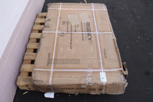 Regency Spec Line ESS-3048-314 30"x48" stainless steel equipment stand in damaged original packaging on pallet.