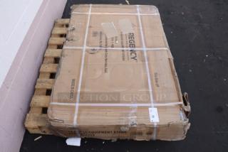 Regency Spec Line ESS-3048-314 30"x48" stainless steel equipment stand in damaged original packaging on pallet.