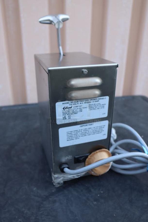Brand new Edlund 203 electric can opener, tabletop model, two-speed, 115V, with visible wiring. Original packaging damaged.