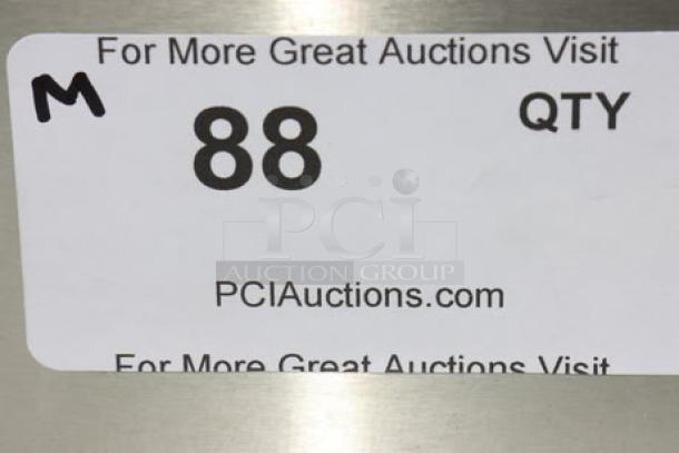 Label on stainless steel work table indicating auction lot number 88 and auction site PCIauctions.com.