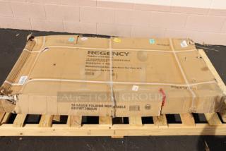 New Regency FWT-3060-US-418 30"x60" stainless steel folding work table in damaged original packaging, 18-gauge, with removable undershelf.