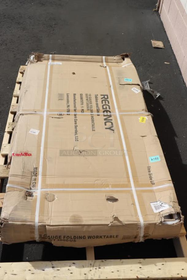 Brand new Regency FWT-3060-US-418 30" x 60" stainless steel work table in damaged original packaging.