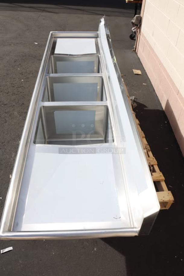 Brand new Regency Spec Line PCS3C162014-24LR stainless steel 3-compartment sink with two drainboards, dented backsplash.