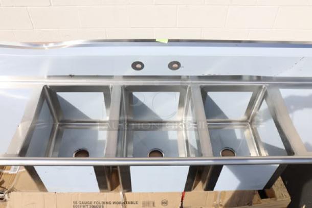 Brand new Regency Spec Line PCS3C162014-24LR stainless steel three-compartment commercial sink with dented backsplash.