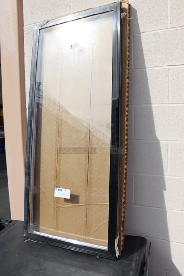 Replacement glass door for refrigerator/freezer, new condition, with black frame, packaged in cardboard.