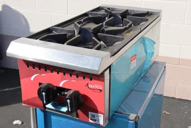 Brand new Avantco Chef Series CAG-R-2-12, 12" 2-burner gas range, 50,000 BTU, minor cosmetic dents, model and serial number visible.