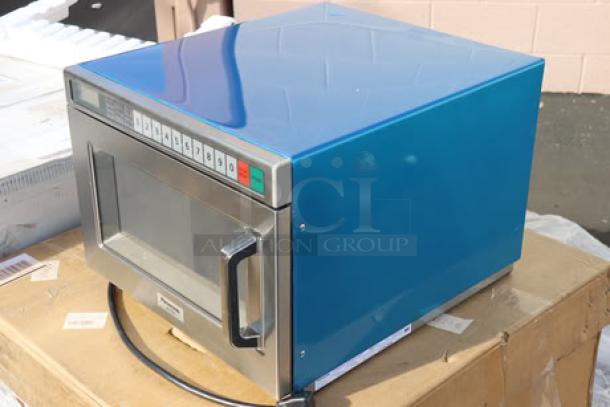 Brand new Panasonic NE-21523 stainless steel commercial microwave oven, 208/240V, 2100W, on cardboard box.