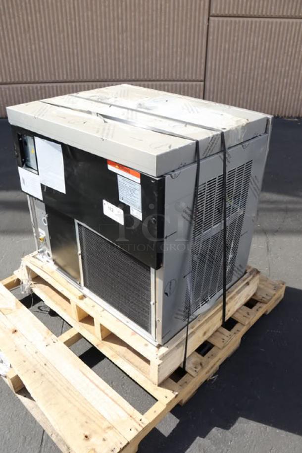 BRAND NEW Manitowoc Air Cooled Ice Machine on pallet. Minor scratches and dents visible. Tags display model and specifications.