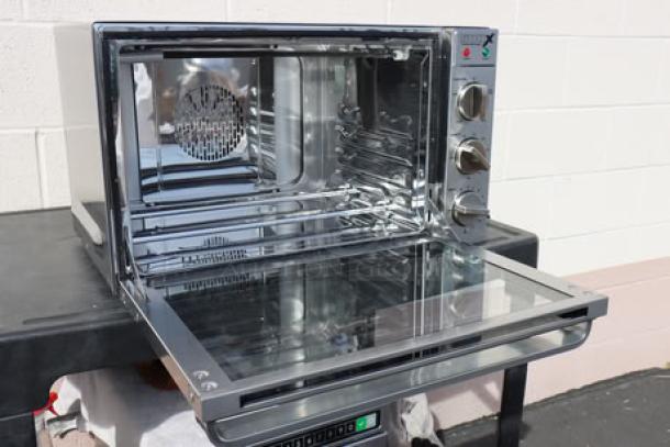 Brand new Waring WCO500X convection oven, half size, 120V 1700W. Identical oven controls visible. Packaging damaged.