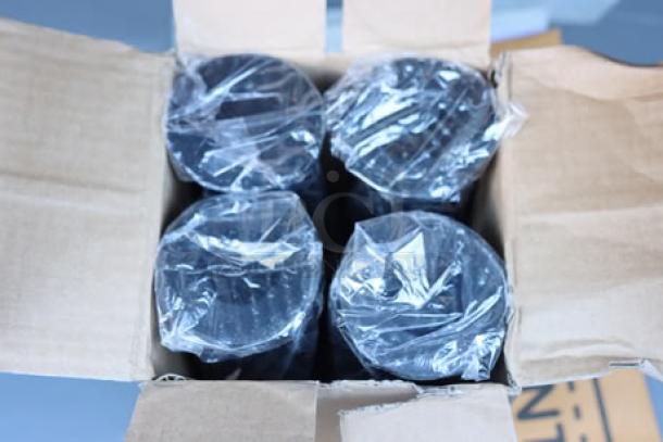Open box with four plastic-wrapped black cylindrical items inside. Box is slightly worn.
