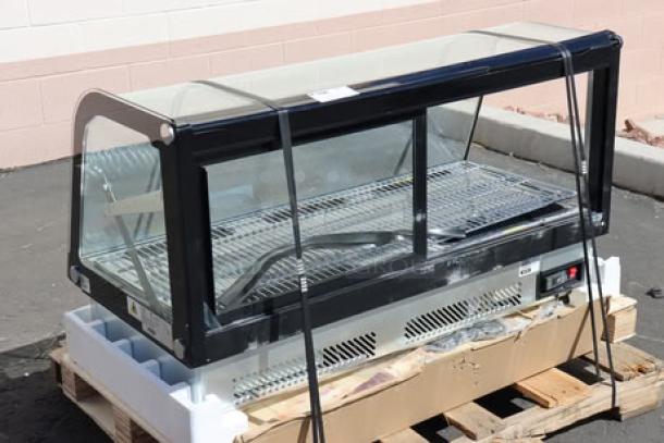 Brand new Avantco BCDI-48, 48" black curved refrigerated display case on a pallet, with minor scratches.