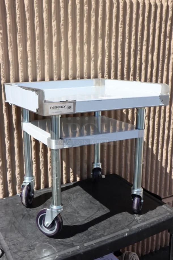 Regency 600ES2424GK stainless steel equipment stand, 24"x24", with galvanized undershelf, casters; minor scratches visible.