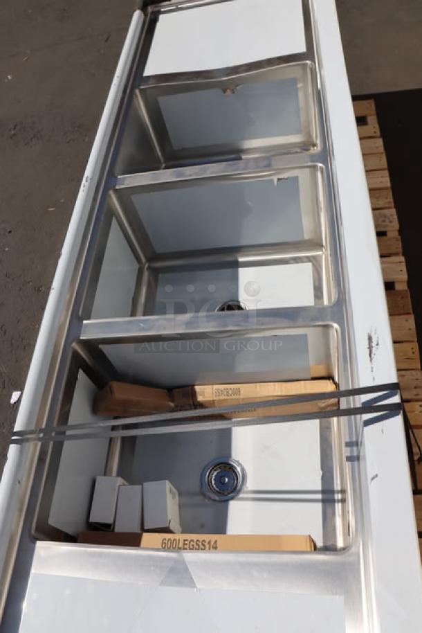 BRAND NEW Regency 600S31824224 stainless steel 3-compartment sink with dual 24" drainboards, 16 gauge, visible labels.