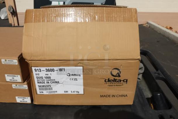 Cardboard box labeled "delta-q technologies" containing the charger for a new Advance SC901 ST 28D floor scrubber.