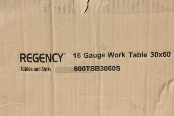 Regency 600TSB3060S 30"x60" 16-gauge stainless steel work table box; label shows model and dimensions; box is damaged.