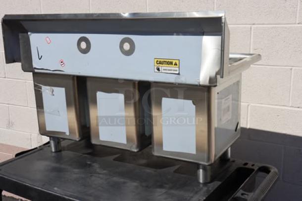 Regency 600S31014 stainless steel three-compartment sink, new scratch-n-dent condition, 39", galvanized legs, caution label.