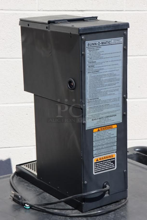 Brand new Bunn 22104.0000 G1 HD 1 lb. black bulk coffee grinder, 120 volts, 9 amps, visible operational labels and warnings.