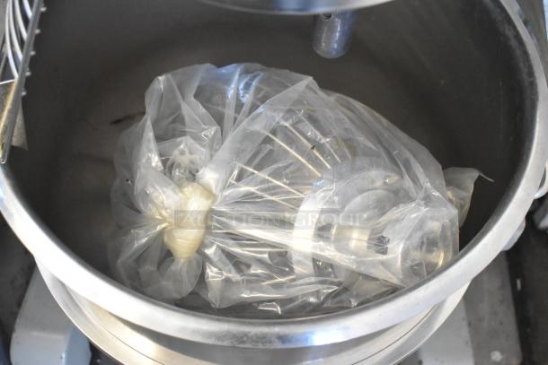 Globe SP40 40 Quart Planetary Mixer with mixing bowl, bowl guard, and attachments wrapped in plastic. 220V, 1-phase.