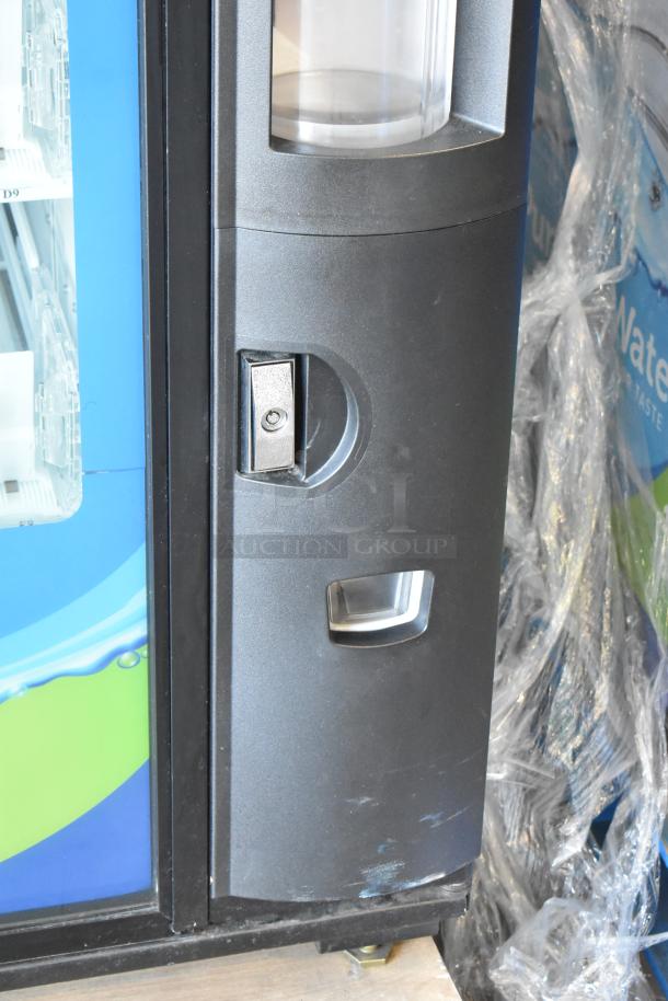 Commercial bottled drink vending machine with bill acceptor, blue and black exterior, slightly scratched, plastic-wrapped.