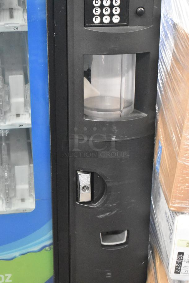 Commercial bottled drink vending machine with bill acceptor, keypad, and coin slot. Slight surface wear visible.