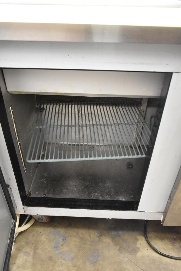 Leader ESLM48S/C prep table interior view, showing shelving and signs of wear. Commercial casters visible underneath.