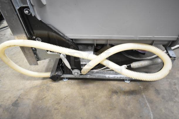 General Electric GE undercounter dishwasher, 115 volts, 1 phase, shown with attached drainage hose in good condition.