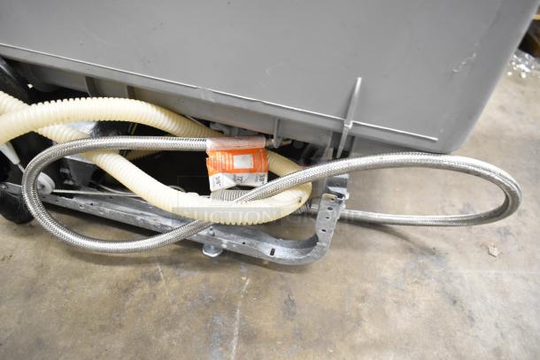 General Electric GE undercounter dishwasher, 115 volts, 1 phase, visible hoses and metal brackets, used condition.