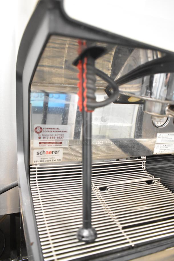 Schaerer Barista countertop automatic espresso machine with 2 groups, 5 portafilters, and steam wands. Visible labels and controls.