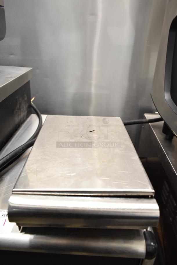 Schaerer Barista espresso machine with two groups, five portafilters, steam wands; visible stainless steel panel.