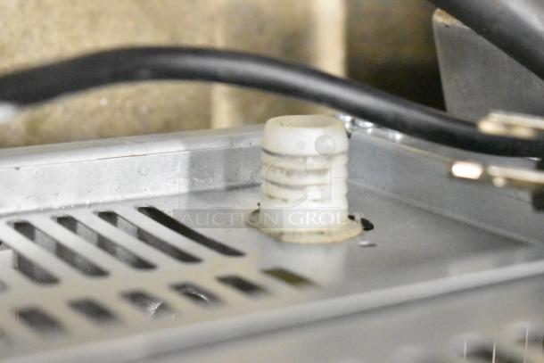 Close-up of the 2024 Avantco 194UCB77A Commercial Undercounter Ice Machine interior showing metal panel and tubing.