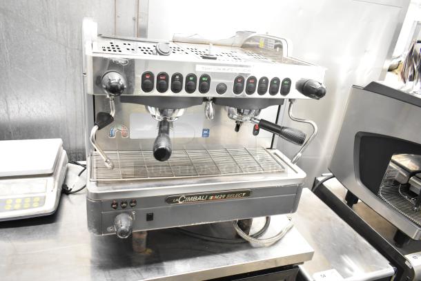 La Cimbali M29 Select 2-group espresso machine with portafilters, steam wands; used condition, stainless steel exterior.