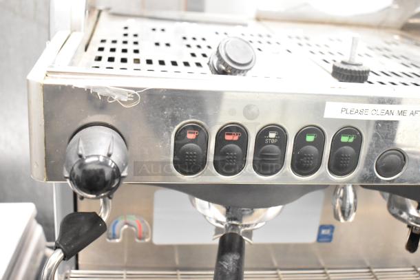 La Cimbali M29 Select commercial espresso machine with 2 groups, showing control buttons and portafilter. Instructions label visible.