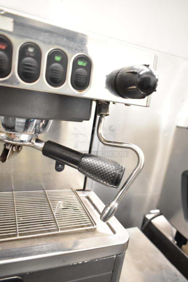 La Cimbali M29 Select 2 Group Espresso Machine with portafilter and steam wand. Stainless steel, buttons on panel.