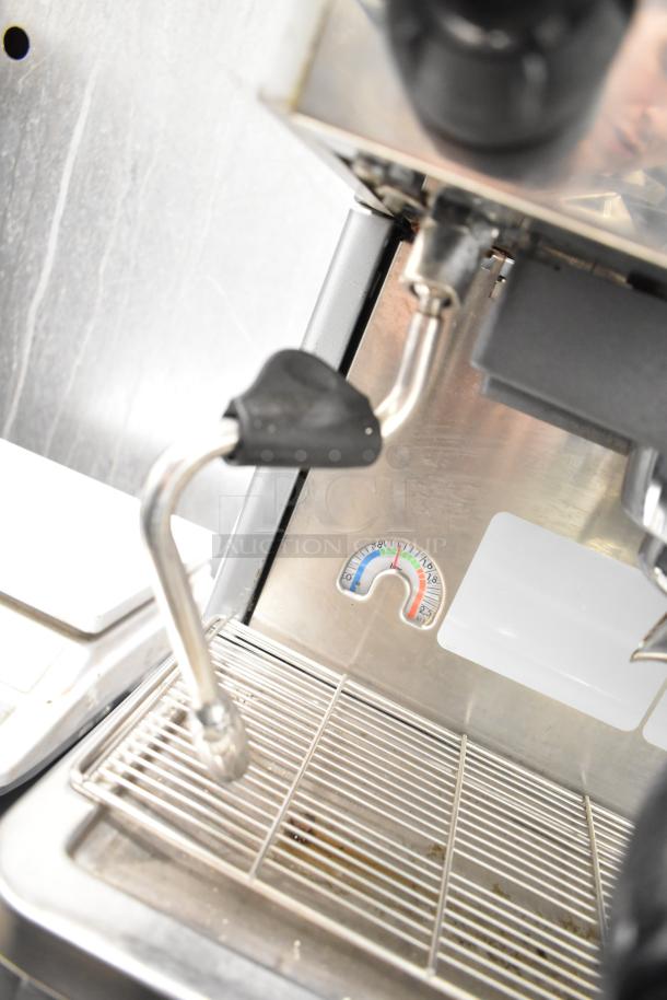 La Cimbali M29 Select commercial espresso machine detail, showing a steam wand, drip tray, and pressure gauge.