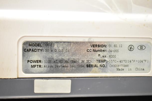 Easy Weigh CK-30 countertop scale label showing 110V, 60Hz power, 30 x 0.005 lb capacity, made by Atron Systems, USA.