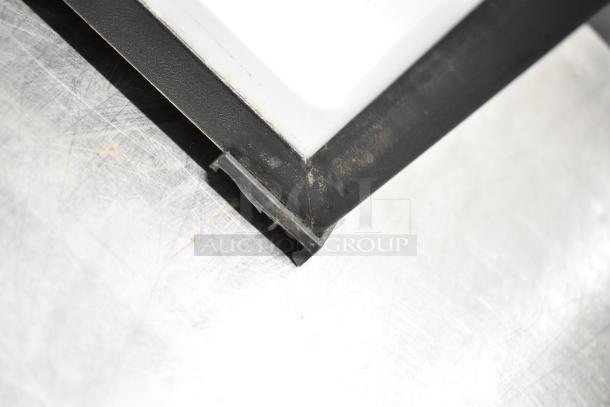 Corner detail of the Summit MBH32GL Mini Cooler Merchandiser, showing exterior wear and black frame.