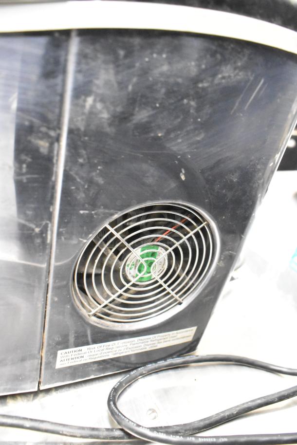 Frigidaire EFIC117-SSBLACK ice machine, countertop model, visible back with fan and caution label, moderate wear.