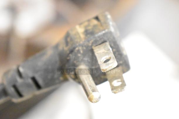 Close-up image of a three-prong plug connected to the Frigidaire EFIC117-SSBLACK Ice Machine, 115V, 1 Phase.