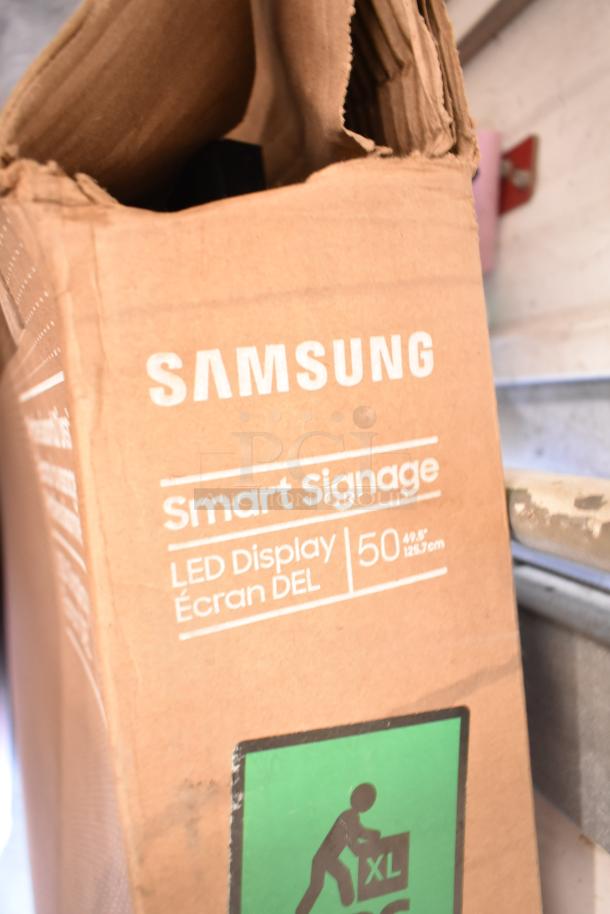 Samsung 50" Smart Signage LED Display box showing brand, model, and size markings. Box condition appears used.