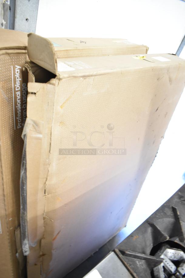Two Samsung 50" Smart Signage LED Displays in boxes. Boxes show signs of wear. Professional Display label visible.