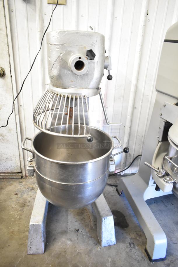 Commercial planetary dough mixer with bowl and guard, floor style, stainless steel, used condition, visible wear.