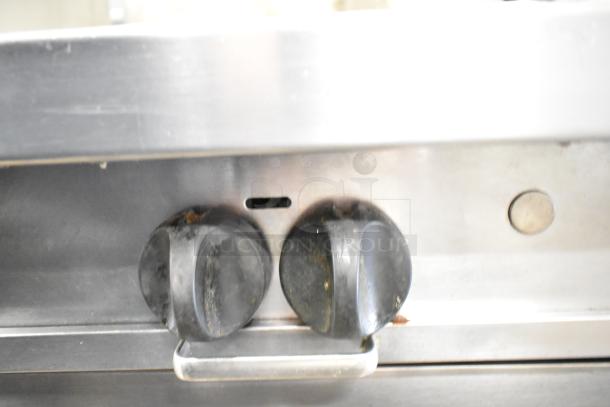 Southbend P32A-BBB range control knobs, stainless steel surface, commercial-grade, visible wear.