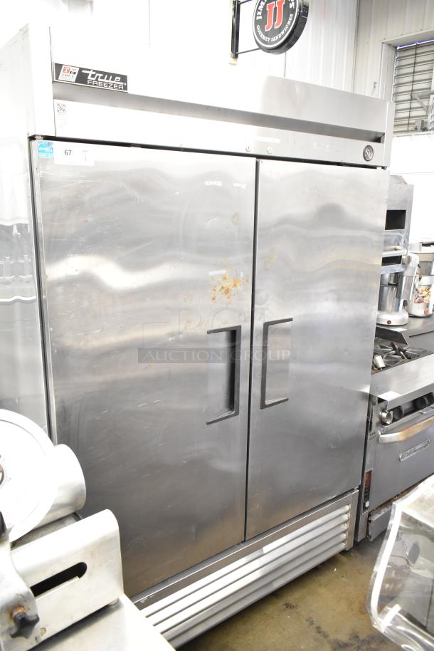 True T-49F Commercial 2 Door Reach-In Freezer, stainless steel, 115 volts, 1 phase, visible wear on doors, model label intact.