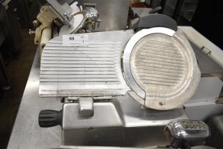2019 Hobart Edge13A-11 meat slicer, includes blade sharpener. Missing carriage and arm. 115V, 1-phase. Auction tag visible.