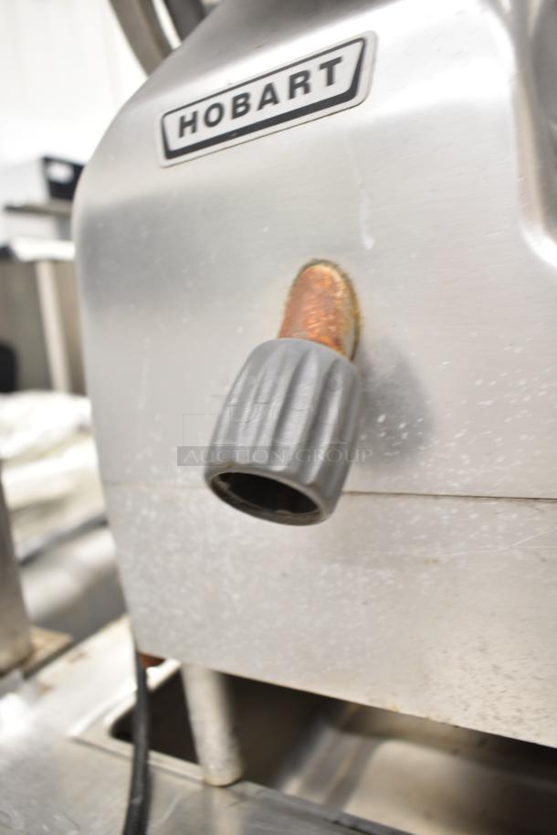 2019 Hobart Edge13A-11 meat slicer, missing carriage and arm, with blade sharpener, 115V, 1 phase. Visible Hobart logo.