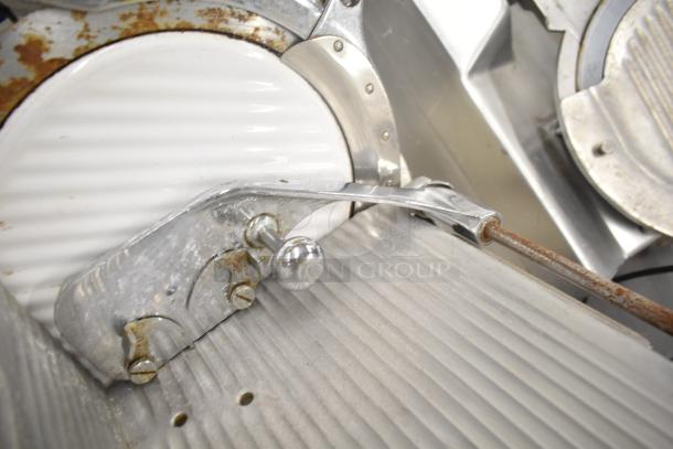 Globe 260 Commercial Meat Slicer with blade sharpener. Visible rust and wear. Runs on 115 volts, 1 phase power.