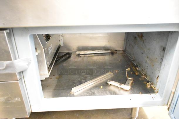 Commercial prep station with 3 wells, 2 drawers, and 1 door. 115V, 1 Phase. Some visible wear and rust inside.